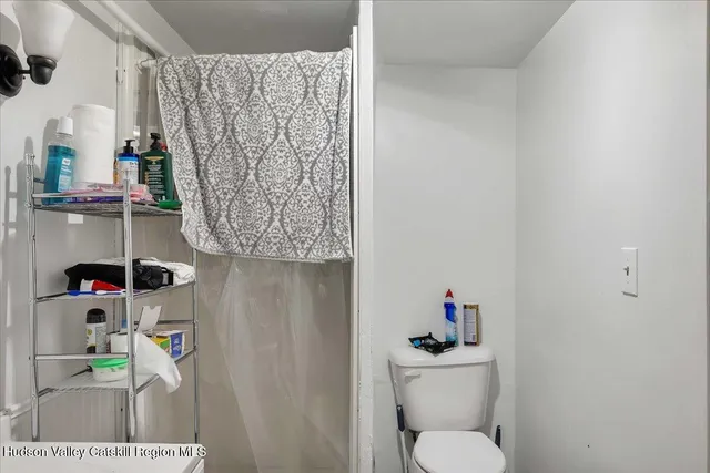 a bathroom with a toilet sink and curtain