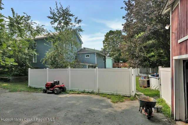 a view of a white house with a chairs and table in a patio