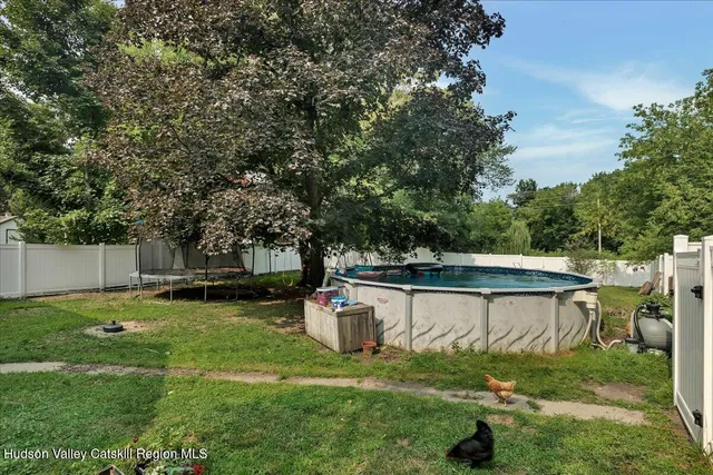 a view of a backyard with a small pool and sitting area