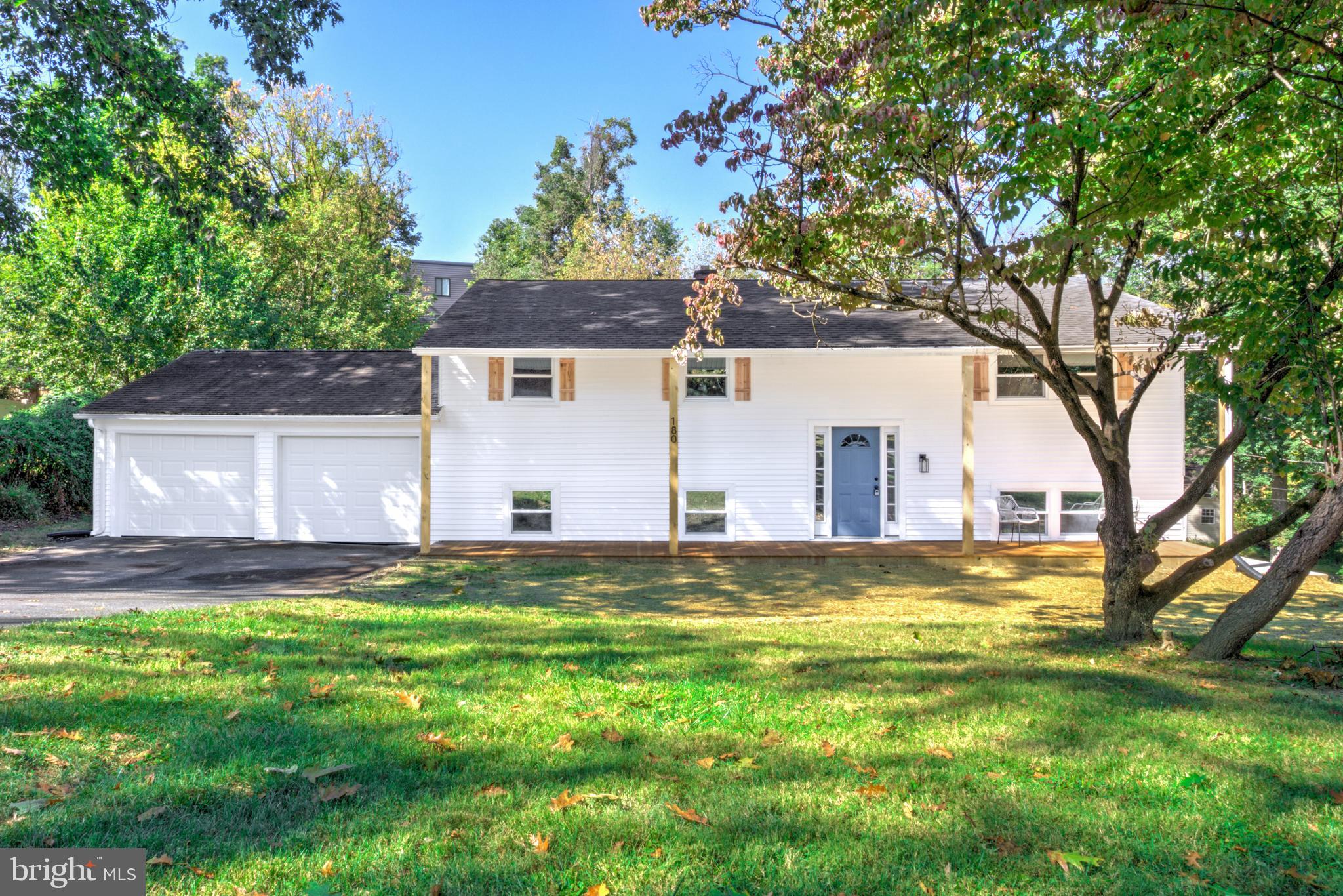 a view of a house with a yard and large tree