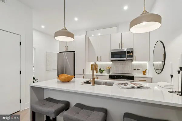 a kitchen with stainless steel appliances a sink a table and chairs