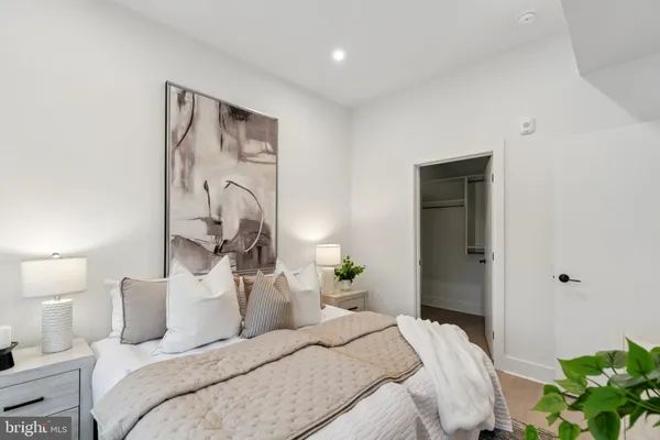 a bedroom with a bed and a potted plant
