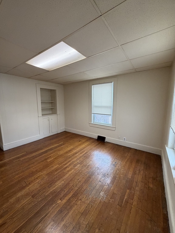 90 Bacon Street, Unit 1 Waltham, MA 02451 - Photo 3 of 9 an empty room with wooden floor and windows