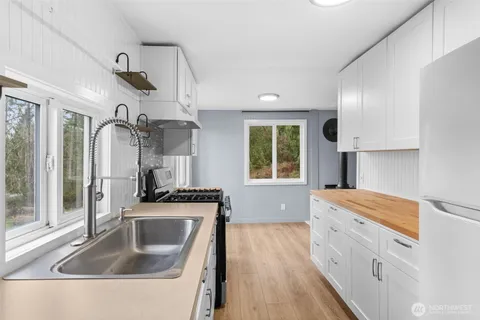 a kitchen that has a sink a stove and window