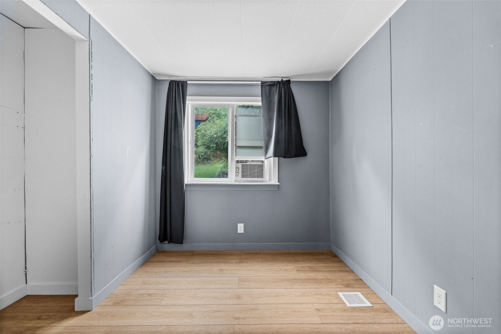 18818 Slough Lane Southeast Yelm, WA 98597 - Photo 22 of 39 a view of an empty room with wooden floor and a window