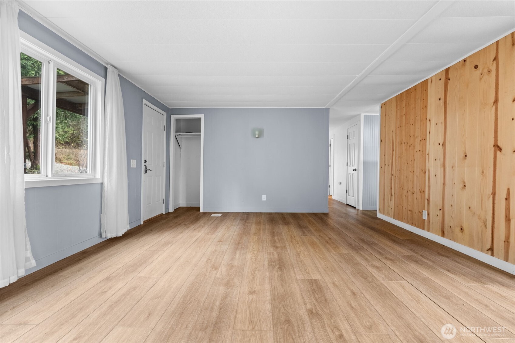 18818 Slough Lane Southeast Yelm, WA 98597 - Photo 9 of 39 a view of an empty room with wooden floor and a window