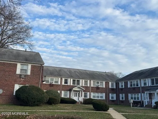 a front view of a residential apartment building with a yard