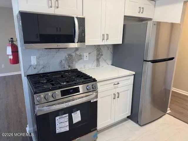 a stove top oven sitting inside of a kitchen