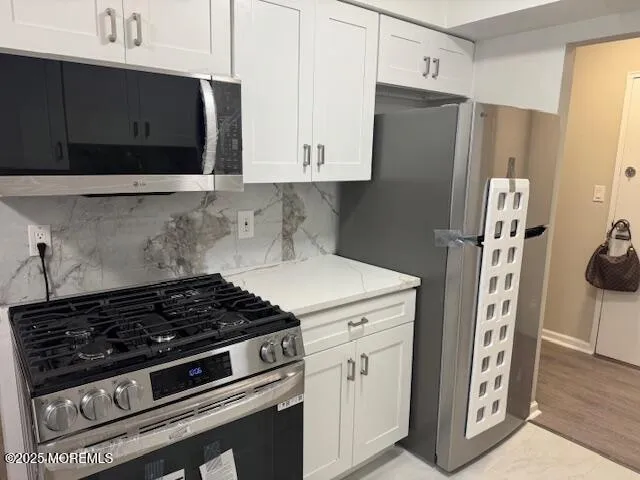 a kitchen with stainless steel appliances a stove a refrigerator and cabinets