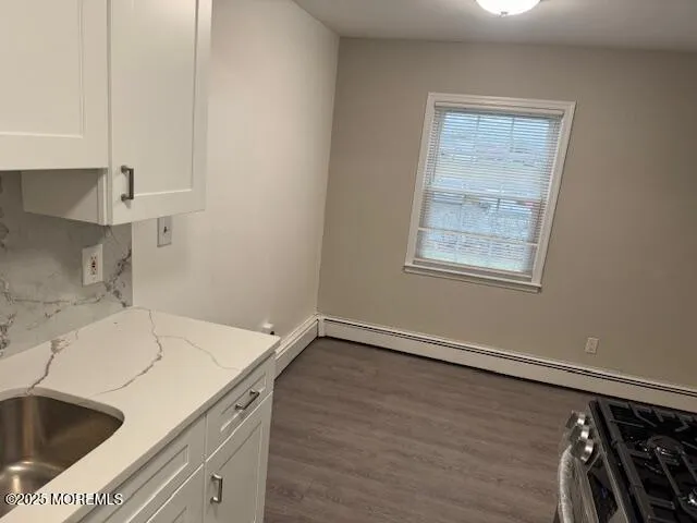 a view of a kitchen that shows a sink wooden floor and a window