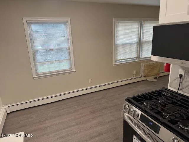 a kitchen with granite countertop a stove and a wooden floor