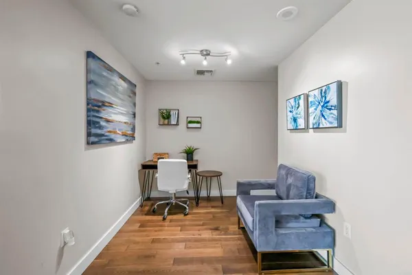 a living room with furniture and a dining table with wooden floor