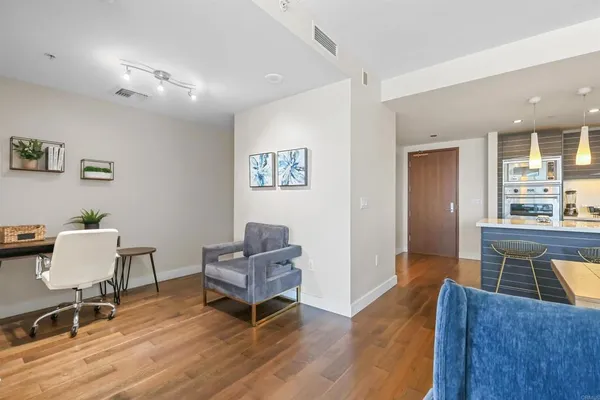 a living room with furniture and a wooden floor