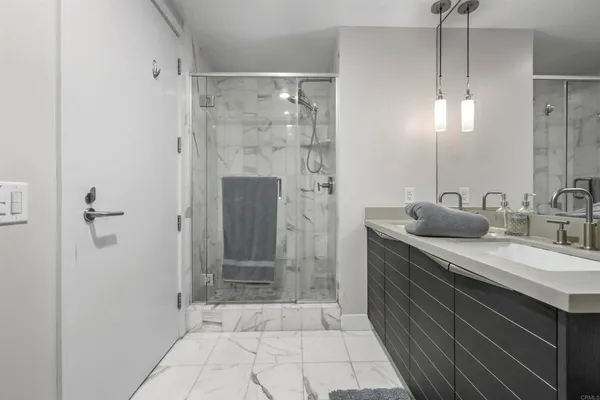 a bathroom with a shower sink and mirror
