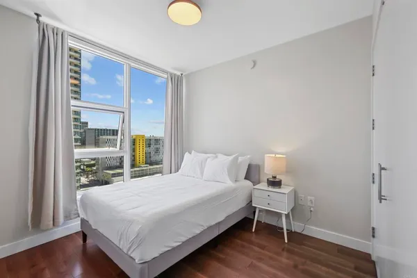 a bedroom with a bed and wooden floor