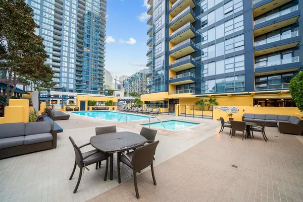 a swimming pool with outdoor seating and city view
