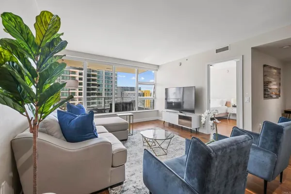 a living room with furniture a large window and a wooden floor