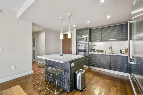 a kitchen with stainless steel appliances kitchen island granite countertop a table and chairs in it