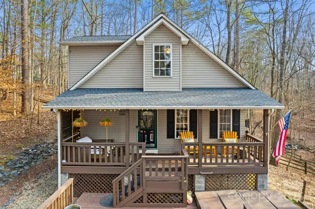 a view of a house with wooden deck and furniture