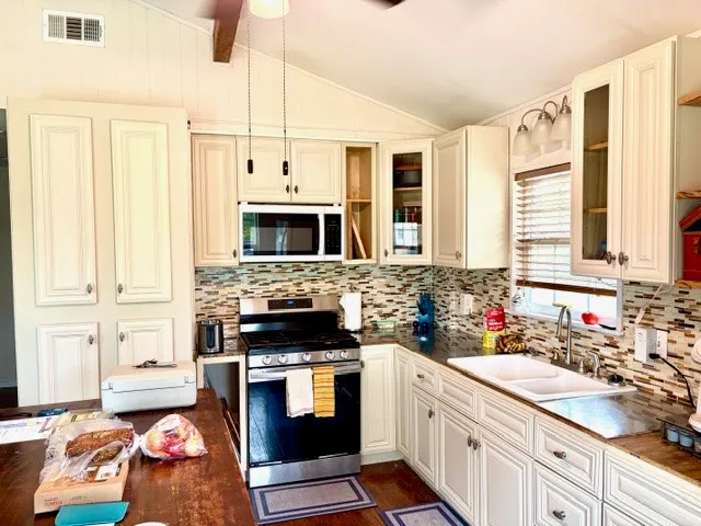 a kitchen with stainless steel appliances a stove a sink and a microwave