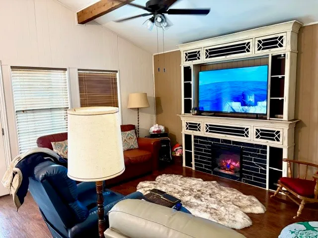 a living room with furniture a flat screen tv and a fireplace