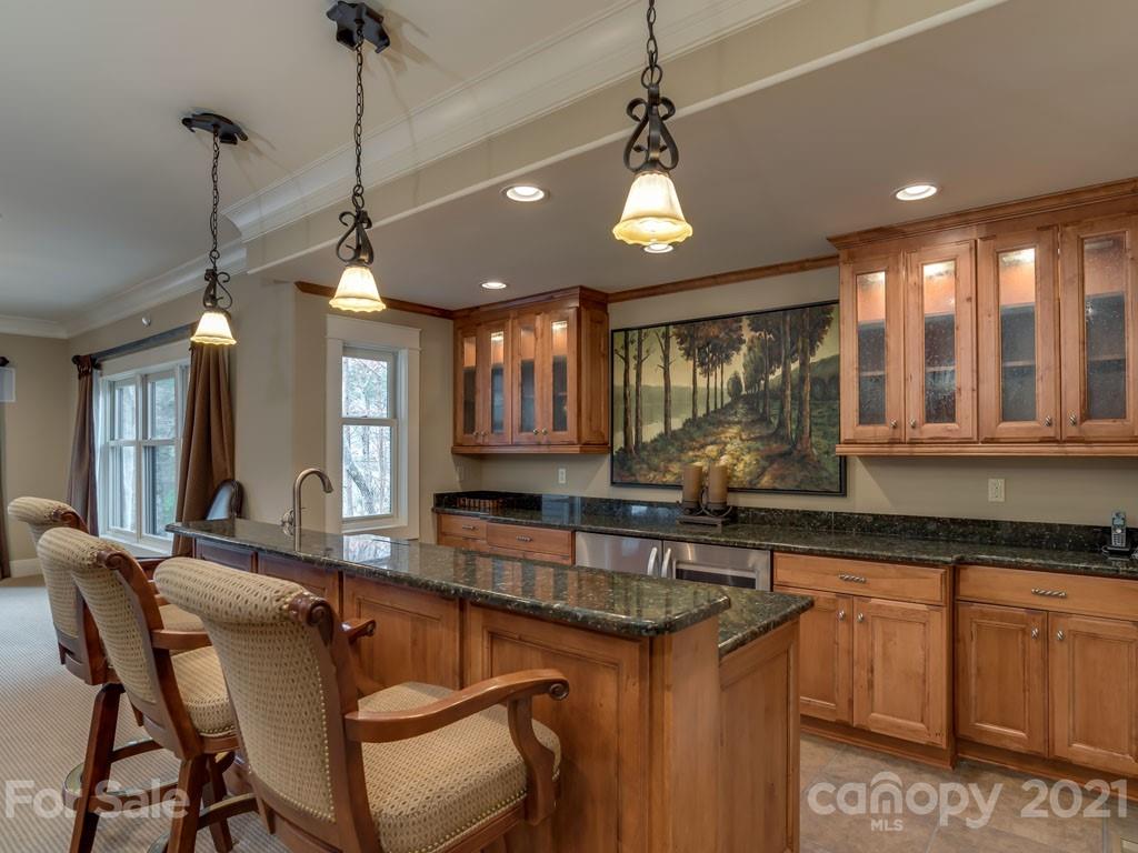 995 Deep Gap Farm Road East Mill Spring, NC 28756 - Photo 23 of 47 a kitchen with granite countertop a sink a center island and windows