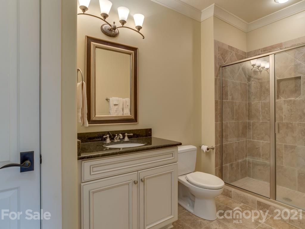 995 Deep Gap Farm Road East Mill Spring, NC 28756 - Photo 25 of 47 a bathroom with a granite countertop sink toilet a mirror and shower