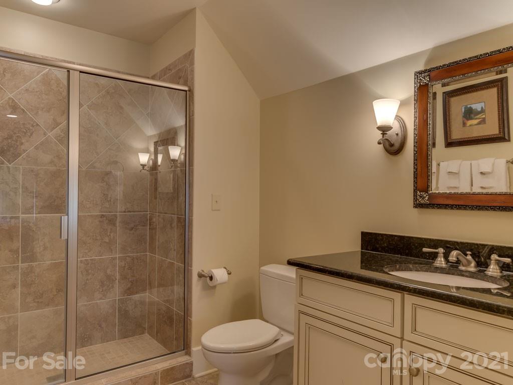 995 Deep Gap Farm Road East Mill Spring, NC 28756 - Photo 35 of 47 a bathroom with a granite countertop sink a toilet a mirror and shower