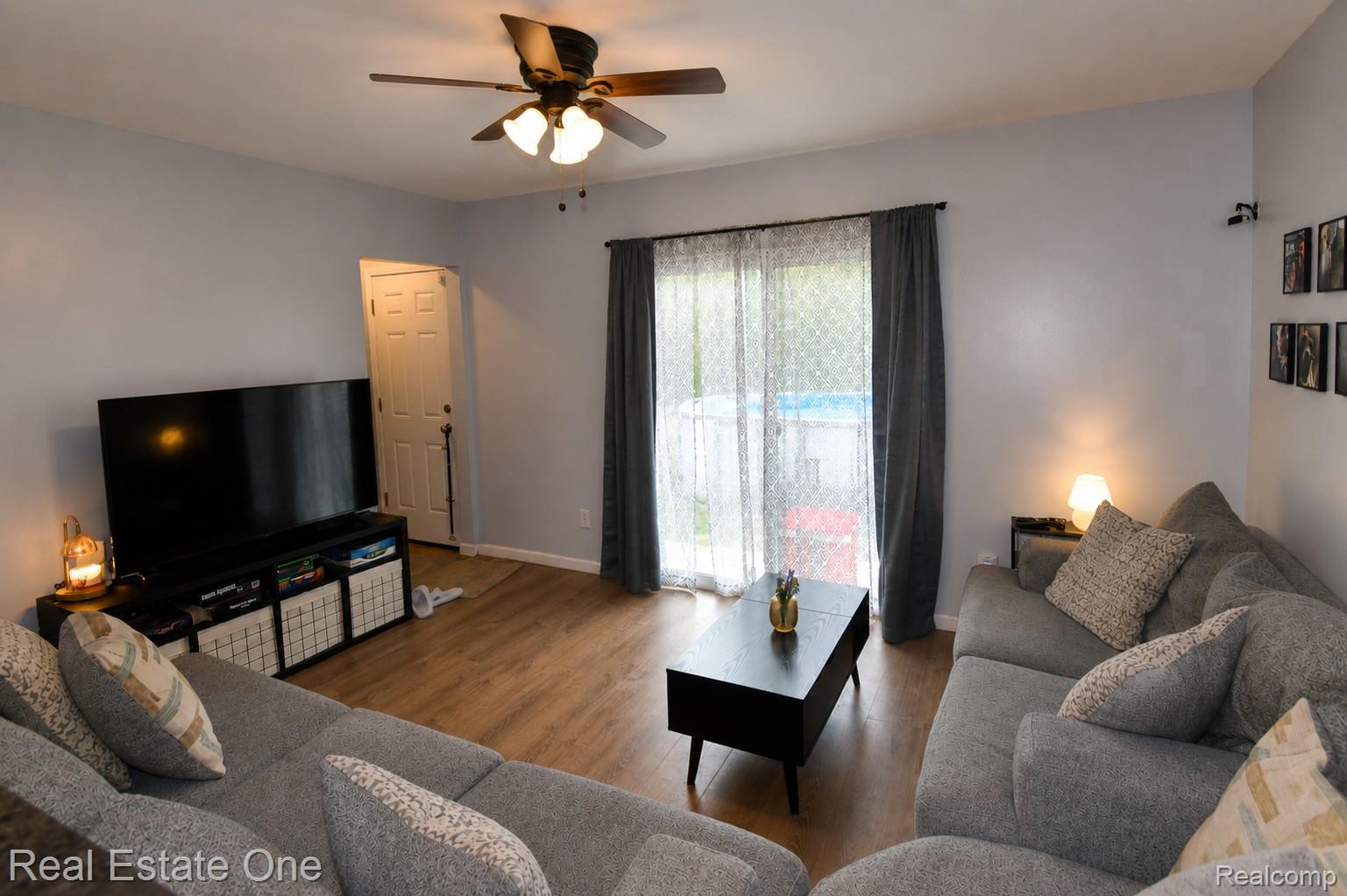 15404 Colbert Street Romulus, MI 48174 - Photo 3 of 23 Living area featuring wood-finish flooring, a ceiling fan with integrated lighting, and a sliding glass door providing exterior access
