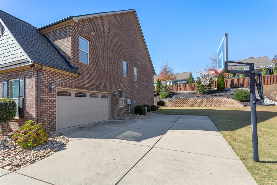 1005 Winmar Drive Anderson, SC 29621 - Photo 2 of 50 This brick residence features a spacious driveway leading to the garage, with an outdoor basketball hoop.