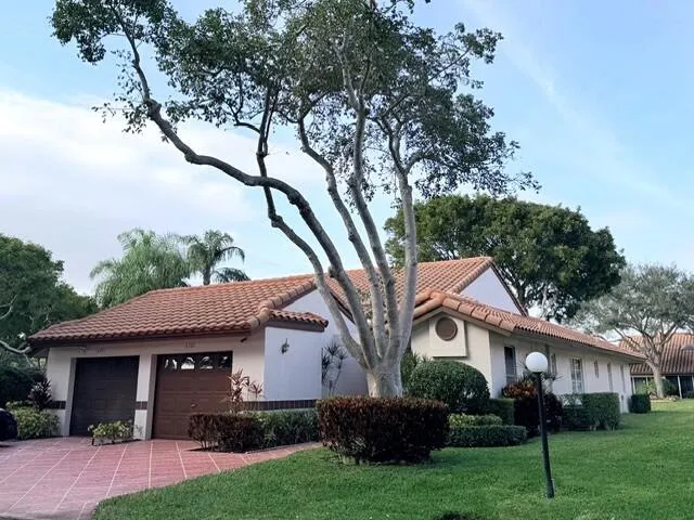 a front view of a house with a garden and yard