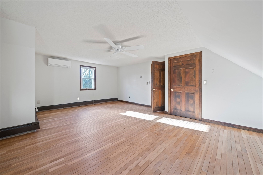 33 Oak Ridge Road Sandwich, MA 02537 - Photo 18 of 42 an empty room with wooden floor ceiling fan and windows