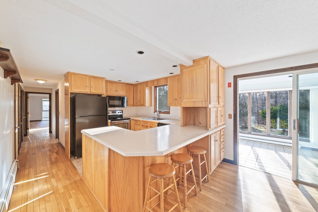 33 Oak Ridge Road Sandwich, MA 02537 - Photo 7 of 42 a large kitchen with kitchen island a large window a sink and stainless steel appliances