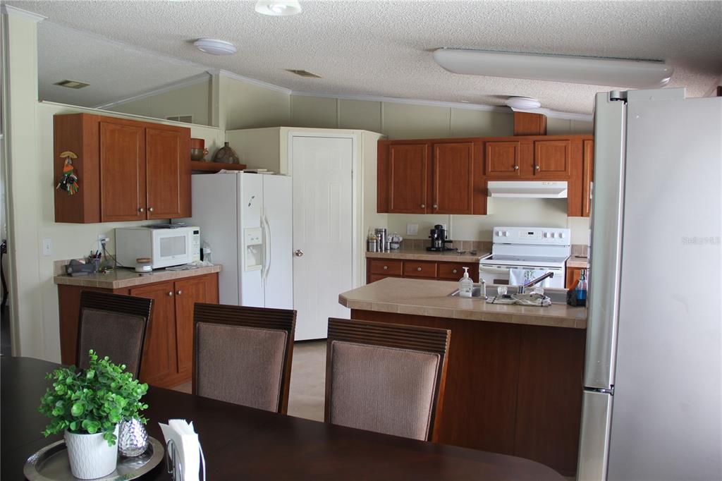 13127 Star Road Brooksville, FL 34613 - Photo 10 of 54 a kitchen with stainless steel appliances kitchen island granite countertop a refrigerator and a sink