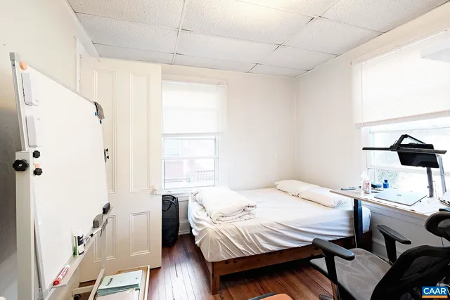a bedroom with a bed and wooden floor