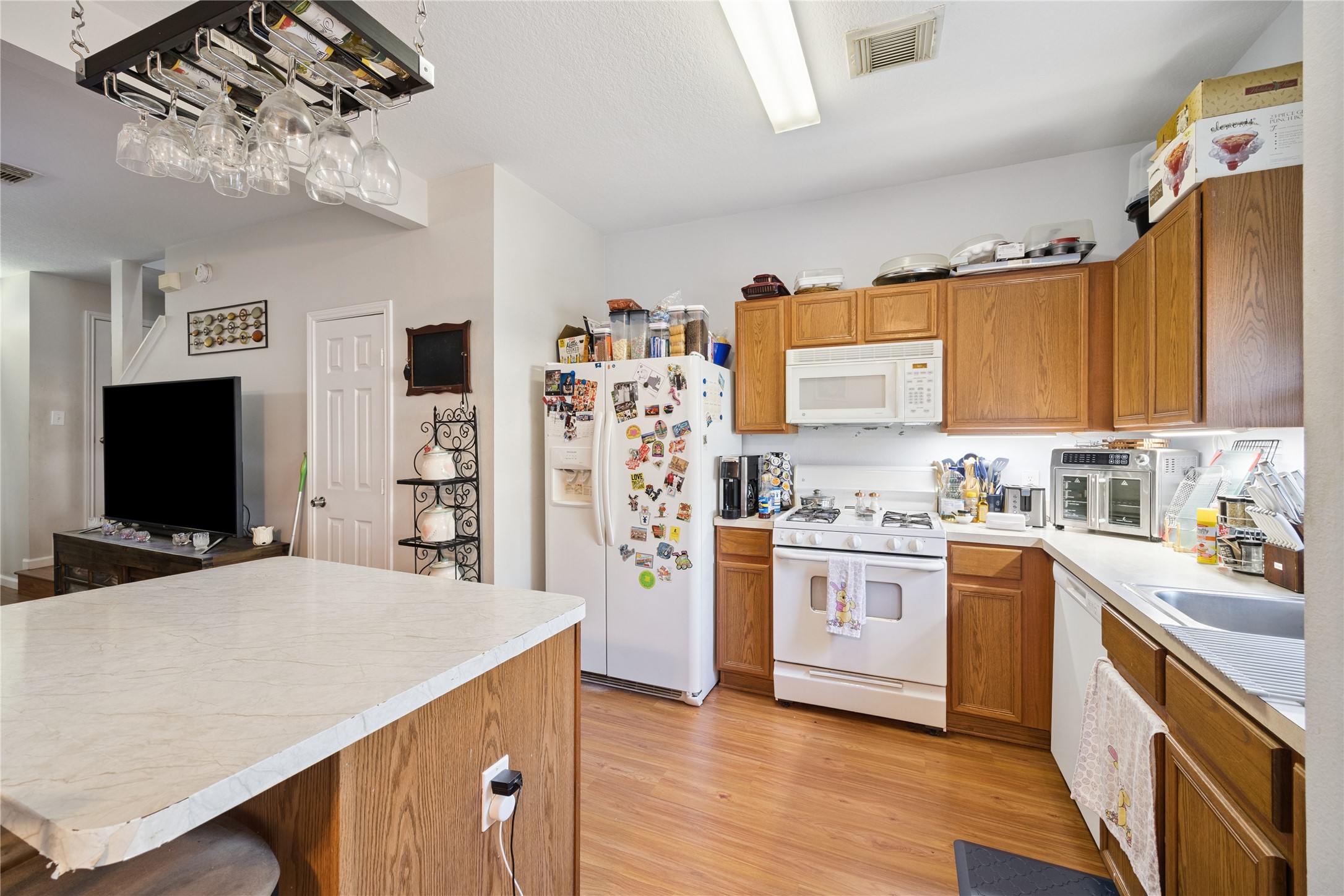 23634 Wildwood Green Way Spring, TX 77373 - Photo 4 of 14 a kitchen with stainless steel appliances a stove a sink dishwasher a refrigerator and a oven with wooden floor