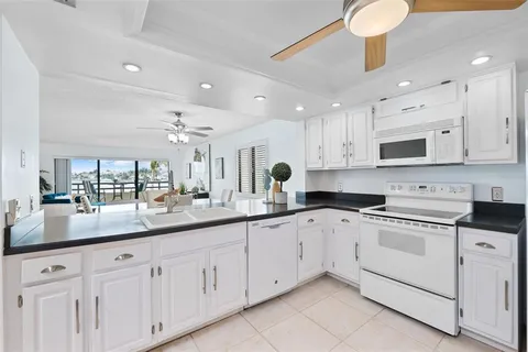 a kitchen with white cabinets and white appliances