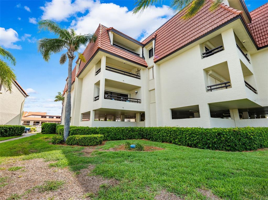 138 1st Street East, Unit 106 Tierra Verde, FL 33715 - Photo 43 of 62 a front view of a house with a yard