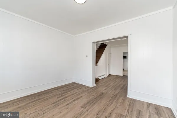 an empty room with wooden floor and white wall