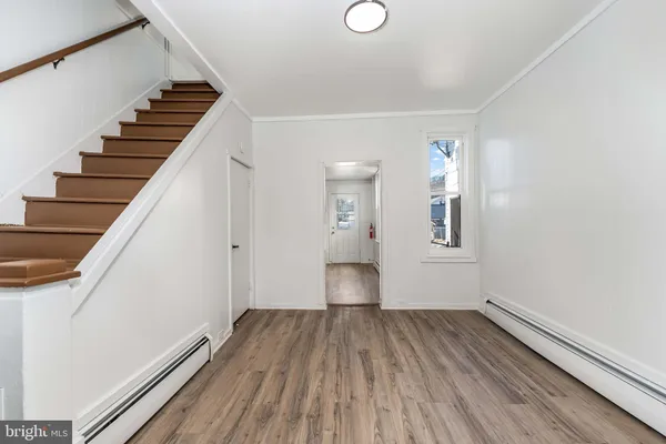 a view of a room with wooden staircase and white walls