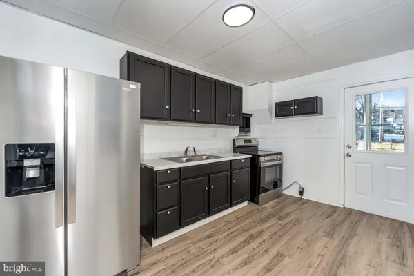 a kitchen with stainless steel appliances granite countertop a refrigerator and a stove top oven