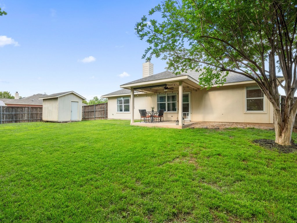1201 Ridgewood Drive Leander, TX 78641 - Photo 28 of 29 Back of property with a storage unit, a patio, a chimney, ceiling fan, and stucco siding