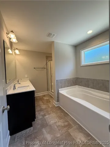 an empty room with windows and chandelier fan