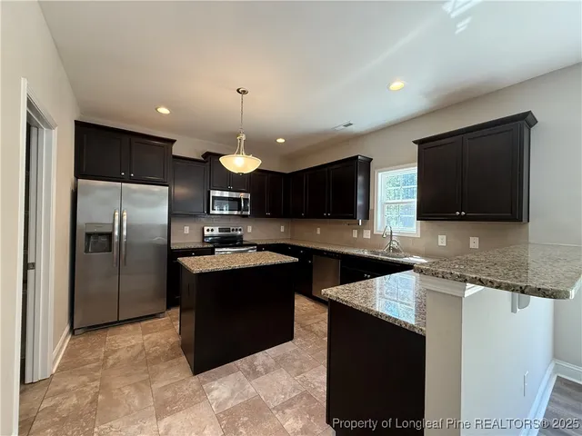 an empty room with windows and chandelier fan