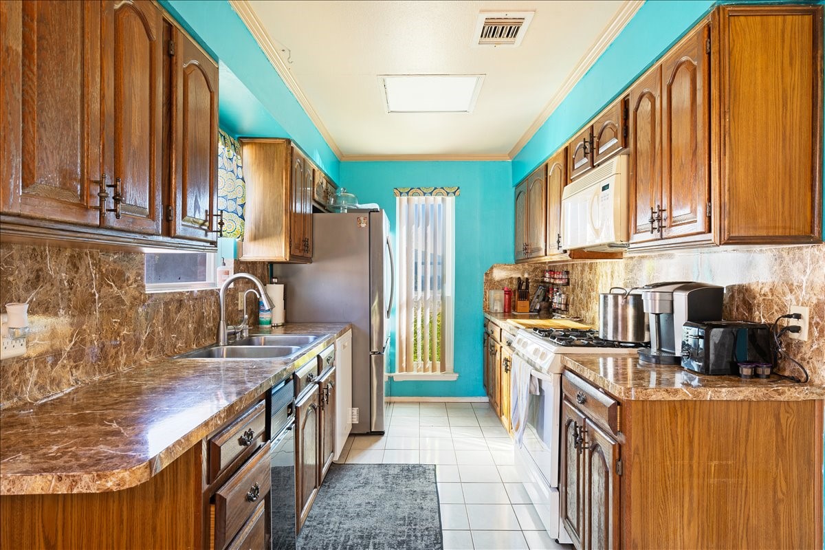 14518 Littleford Street Houston, TX 77045 - Photo 5 of 16 a kitchen with stainless steel appliances granite countertop a refrigerator a stove a sink and dishwasher