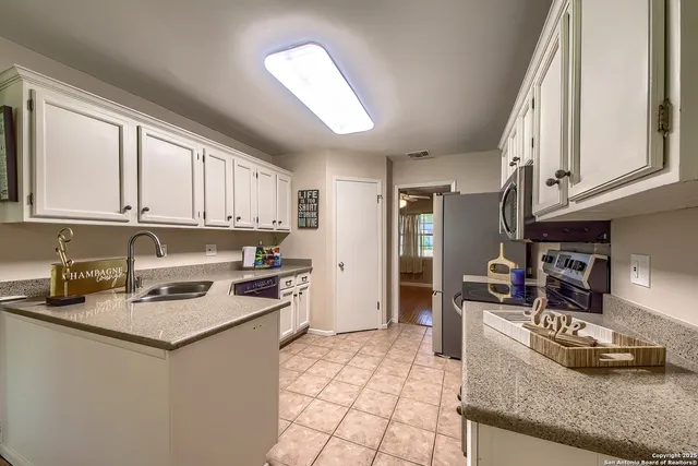 a kitchen with stainless steel appliances granite countertop a stove a sink and a refrigerator