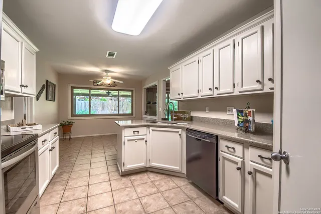 a kitchen with stainless steel appliances granite countertop a stove sink and cabinets