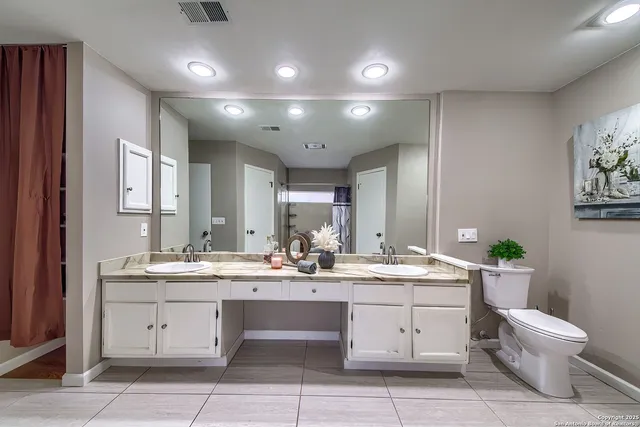 a bathroom with a double vanity sink and a toilet