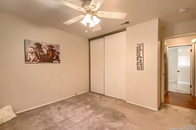 an empty room with windows and fan