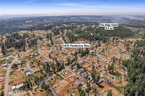 an aerial view of residential building with parking and yard